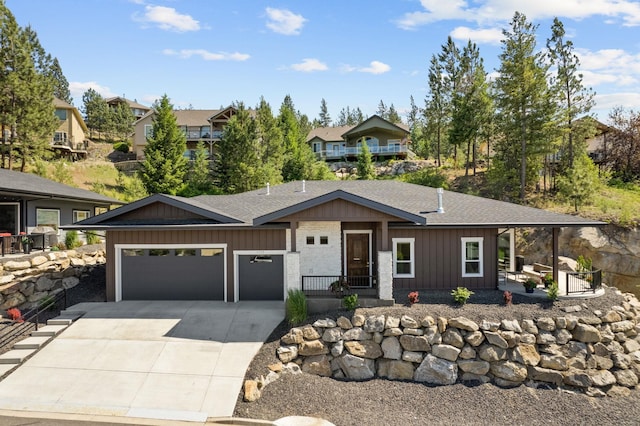 view of front of house featuring a shingled roof, a porch, an attached garage, board and batten siding, and driveway