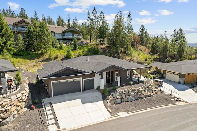 ranch-style home with board and batten siding, roof with shingles, driveway, and an attached garage