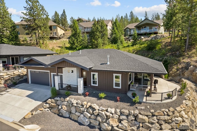 view of front of property with a garage, concrete driveway, board and batten siding, and a residential view