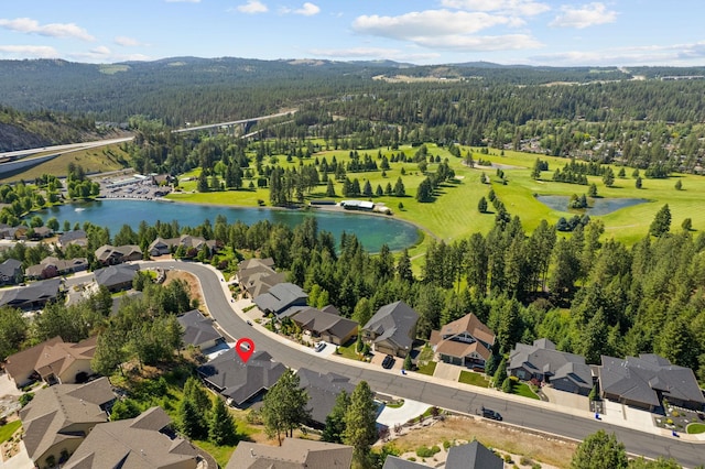 birds eye view of property with a forest view, a water view, and a residential view