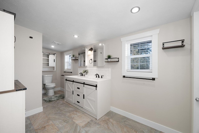 bathroom featuring toilet, baseboards, visible vents, and decorative backsplash