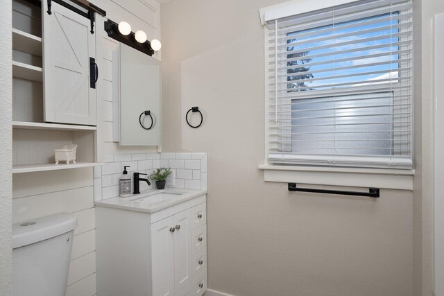 half bathroom with toilet, decorative backsplash, and vanity