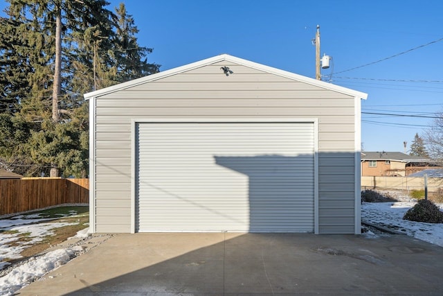 detached garage with concrete driveway and fence