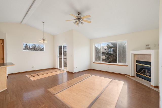 unfurnished living room with lofted ceiling with beams, a tiled fireplace, baseboards, and wood finished floors