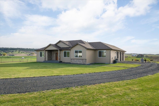 view of front of property with driveway, a garage, fence, central air condition unit, and a front lawn