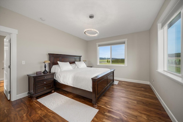 bedroom with dark wood-type flooring and baseboards