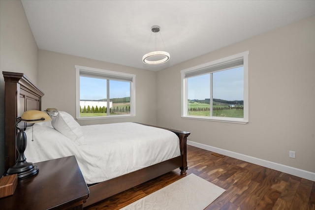 bedroom with baseboards and wood finished floors