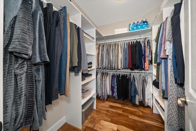 walk in closet with wood finished floors