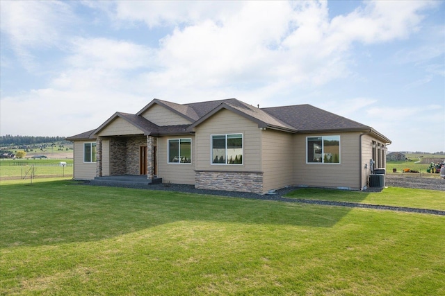 view of front facade featuring a shingled roof, cooling unit, stone siding, and a front lawn