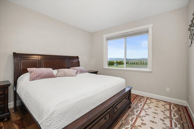 bedroom with baseboards and wood finished floors