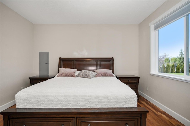 bedroom with baseboards and dark wood-type flooring