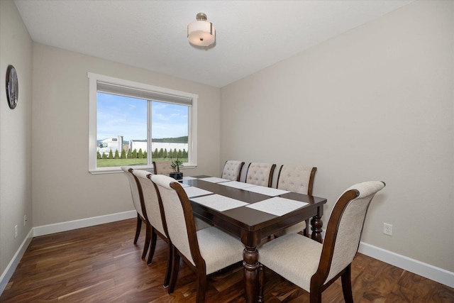 dining area featuring dark wood-style flooring and baseboards