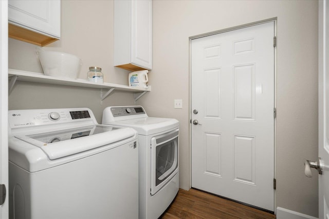 laundry room with dark wood-style floors, washer and dryer, and cabinet space