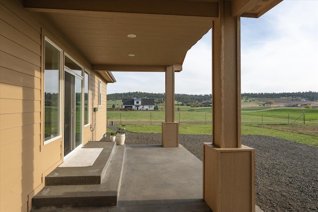 view of patio / terrace with fence and a rural view