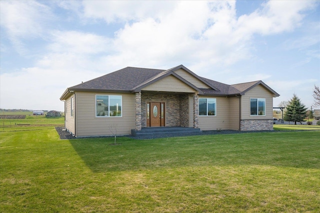 view of front of house featuring a front yard, stone siding, and roof with shingles