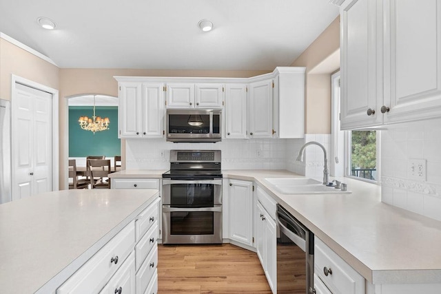 kitchen featuring decorative backsplash, appliances with stainless steel finishes, light countertops, and a sink