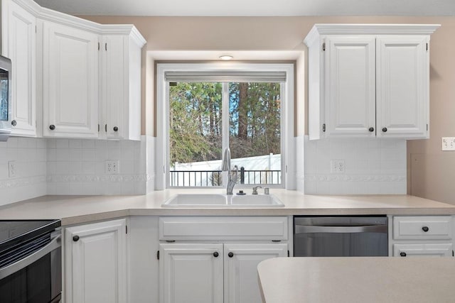 kitchen featuring light countertops, white cabinets, dishwasher, and a sink