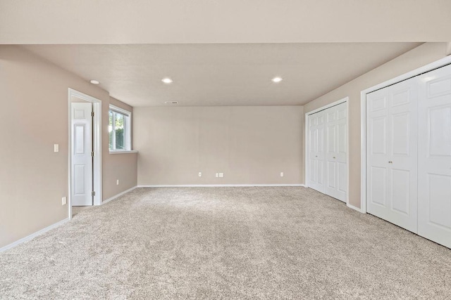 unfurnished bedroom with carpet floors, baseboards, multiple closets, and recessed lighting