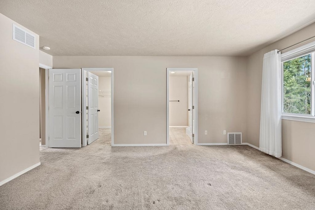 unfurnished bedroom featuring carpet, a spacious closet, and visible vents