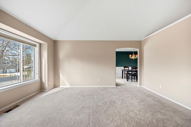 carpeted spare room with arched walkways, lofted ceiling, a notable chandelier, visible vents, and baseboards