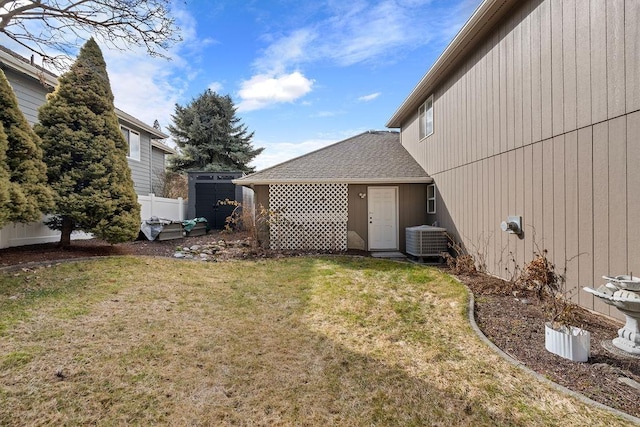 view of yard featuring fence and central AC