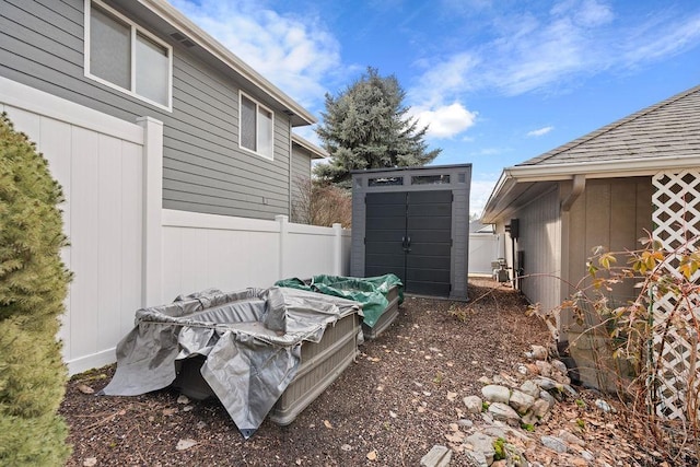 view of yard with a storage shed, fence, and an outbuilding