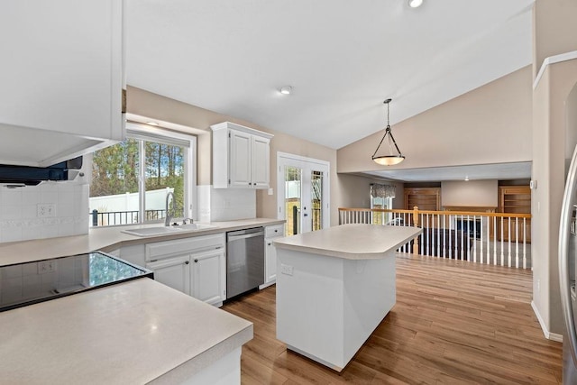 kitchen with lofted ceiling, a sink, white cabinets, light countertops, and stainless steel dishwasher