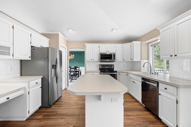 kitchen with appliances with stainless steel finishes, white cabinets, and a sink