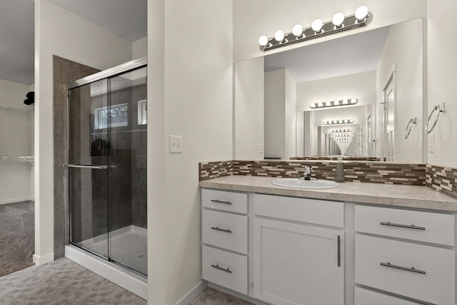 bathroom with tasteful backsplash, a shower stall, vanity, and baseboards