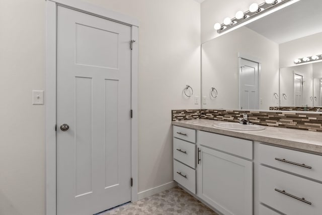 bathroom with tile patterned floors, tasteful backsplash, baseboards, and vanity