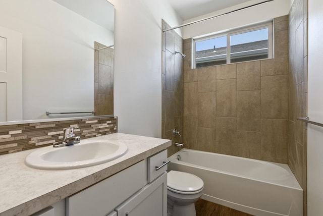 bathroom featuring decorative backsplash, toilet, shower / tub combination, wood finished floors, and vanity