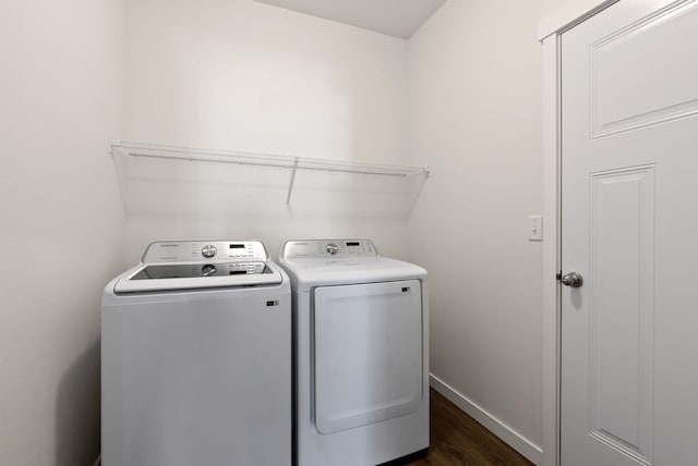 washroom with dark wood-style floors, laundry area, washing machine and clothes dryer, and baseboards