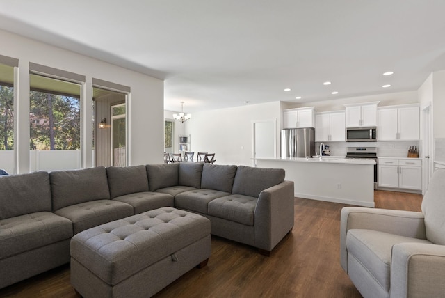 living area featuring recessed lighting, dark wood finished floors, and an inviting chandelier