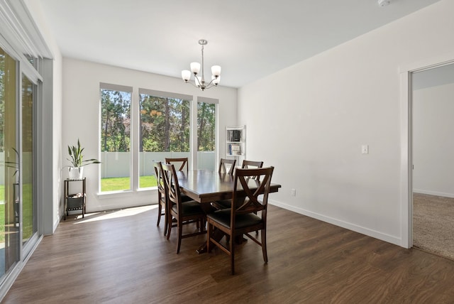 dining room featuring a chandelier, dark wood-type flooring, a wealth of natural light, and baseboards