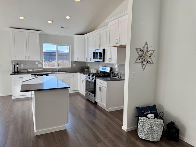 kitchen featuring tasteful backsplash, visible vents, dark wood finished floors, stainless steel appliances, and a sink