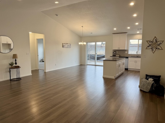 kitchen featuring dark countertops, white cabinetry, dark wood finished floors, and a sink