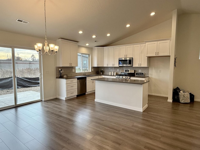 kitchen with dark countertops, visible vents, stainless steel appliances, and a sink