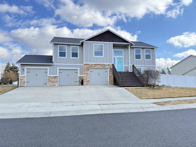 view of front of property featuring a garage, fence, board and batten siding, and concrete driveway