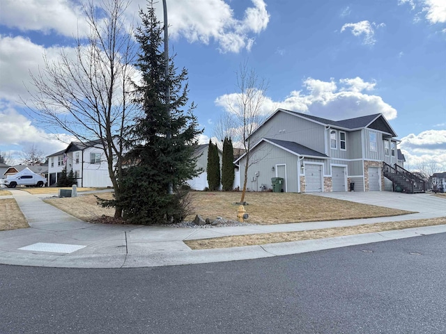 view of side of property with driveway, stairway, and an attached garage