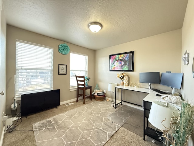 home office featuring visible vents, baseboards, a textured ceiling, and light colored carpet