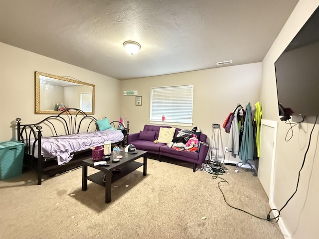 carpeted living room featuring visible vents, plenty of natural light, and a textured ceiling