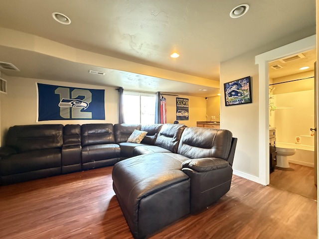 living area featuring visible vents, baseboards, and wood finished floors