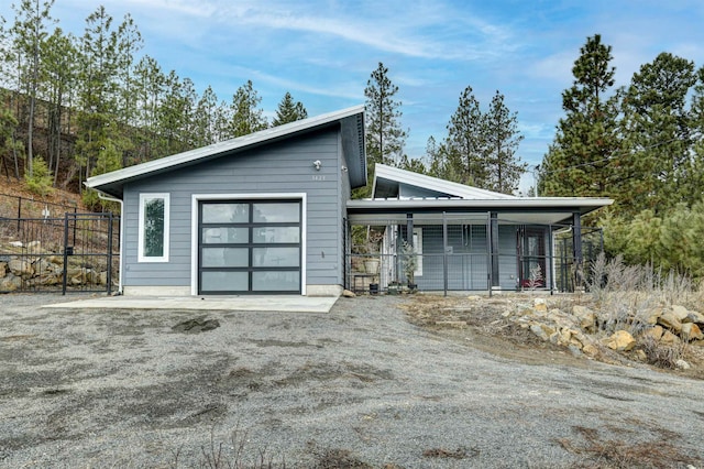 view of front facade with a garage, dirt driveway, and fence