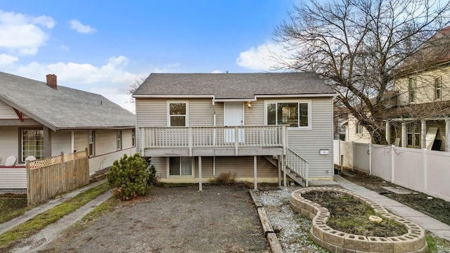 rear view of house featuring stairway, fence, and a wooden deck