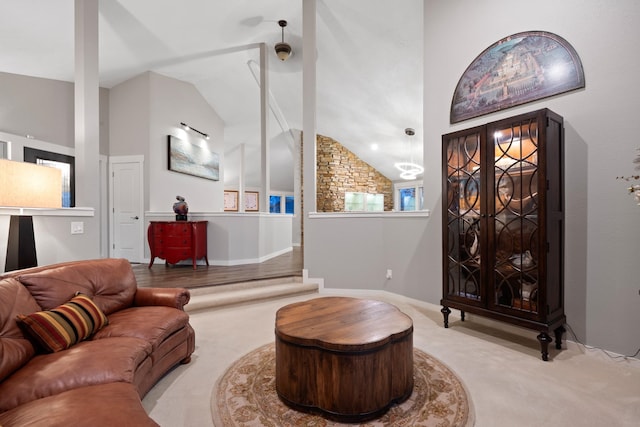 carpeted living area with high vaulted ceiling and baseboards