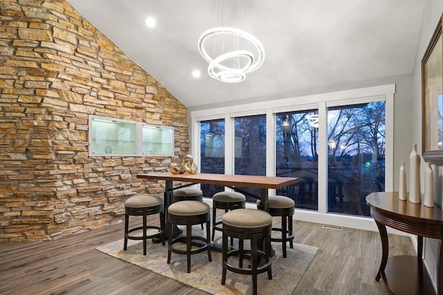 dining area with recessed lighting, visible vents, an inviting chandelier, vaulted ceiling, and wood finished floors