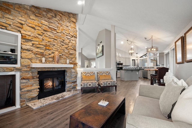 living area with light wood finished floors, a stone fireplace, and vaulted ceiling