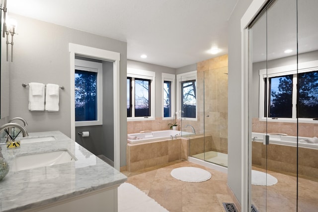 bathroom with double vanity, a stall shower, a bath, tile patterned flooring, and a sink