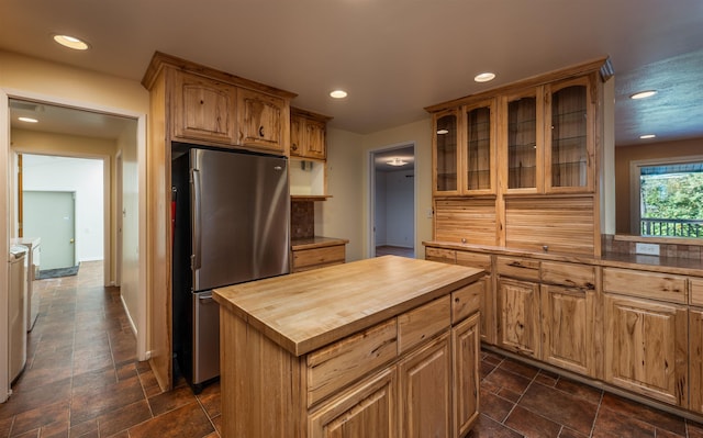 kitchen featuring recessed lighting, stone tile flooring, wooden counters, glass insert cabinets, and freestanding refrigerator