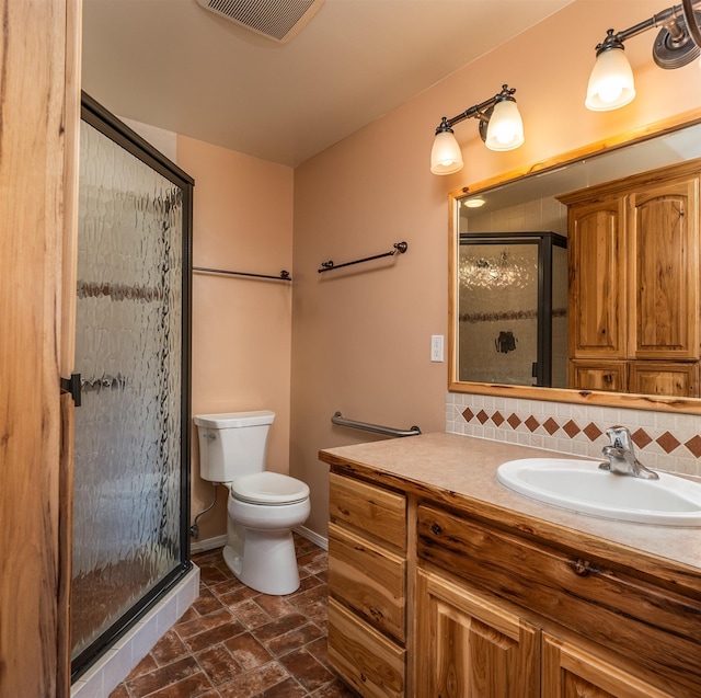 full bath featuring tasteful backsplash, visible vents, toilet, a stall shower, and baseboards